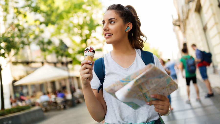 Beautiful woman eating ice cream outdoors while traveling